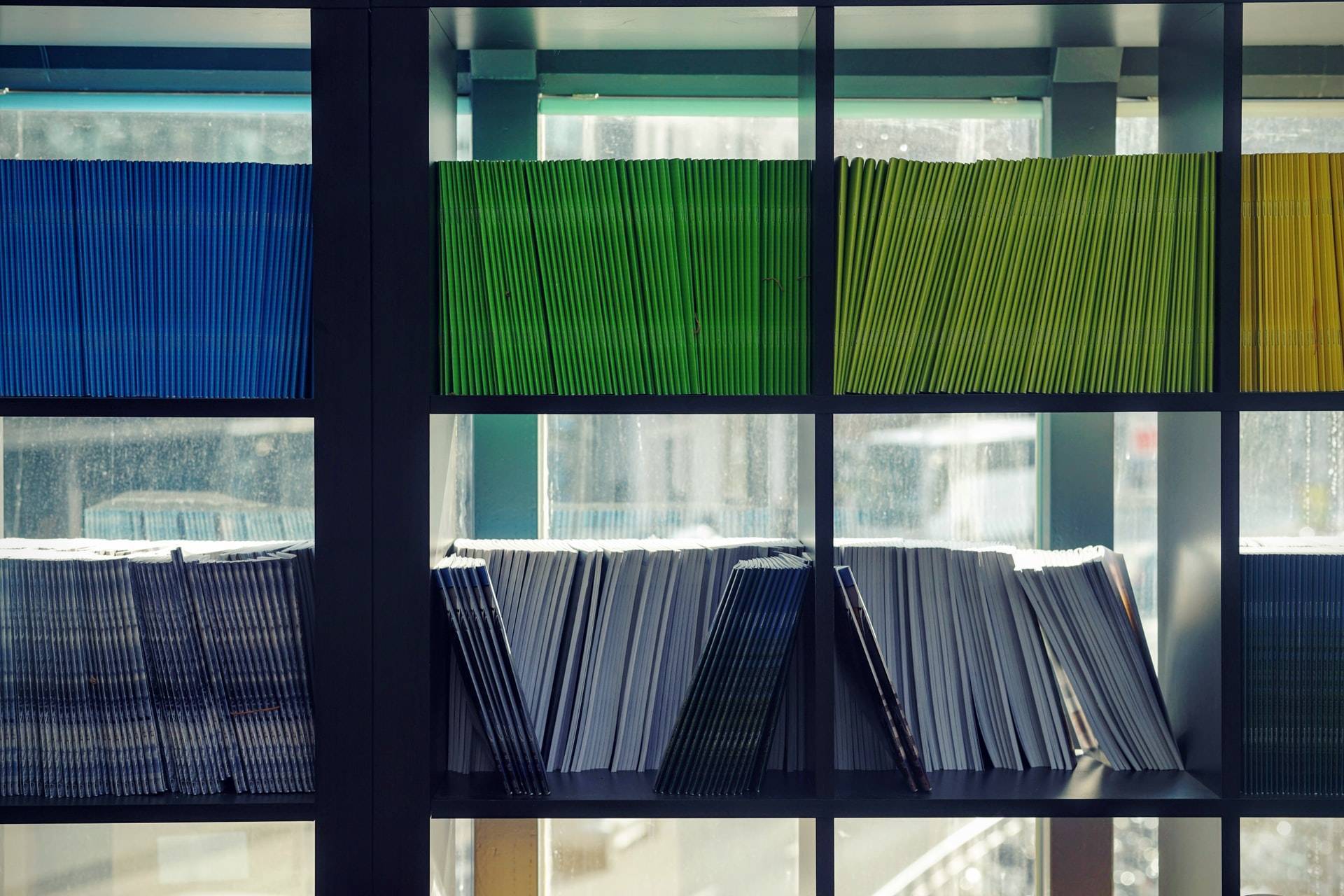 kolorowe foldery poukładane na półkach
